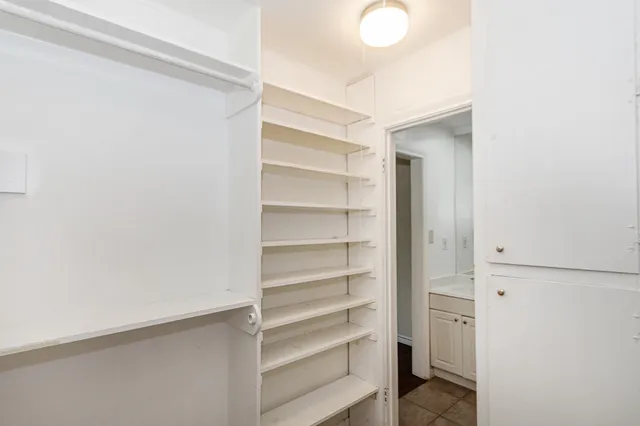 a view of walk in closet with empty racks