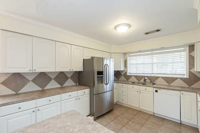 a kitchen with white cabinets and white appliances