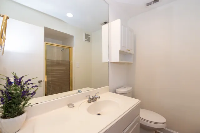 a bathroom with a sink a toilet and shower