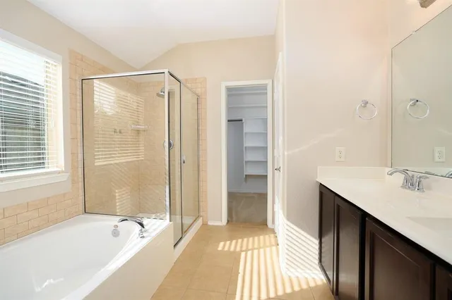 a spacious bathroom with a tub shower and sink