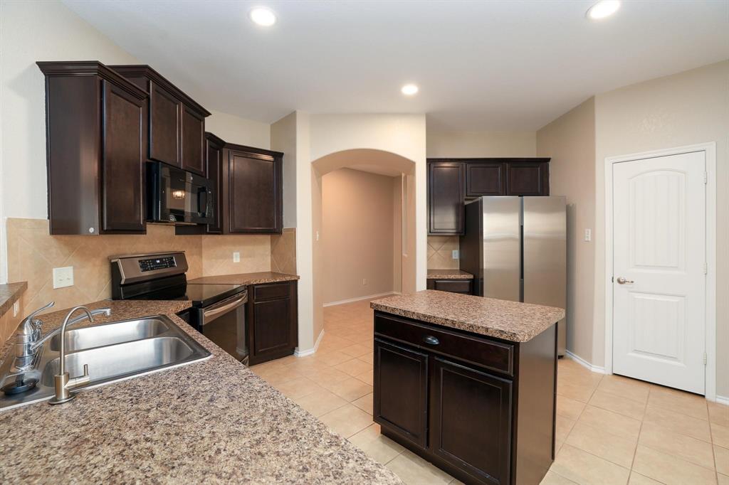 1109 Kaufman Road Melissa, TX 75454 - Photo 4 of 22 a kitchen with stainless steel appliances granite countertop a stove a refrigerator and a sink