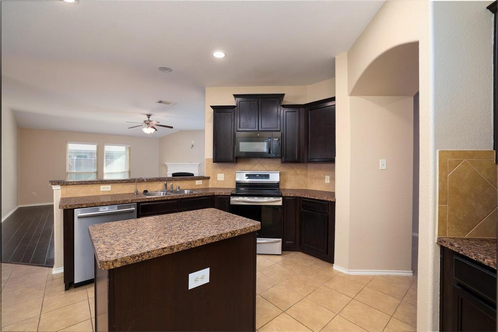 1109 Kaufman Road Melissa, TX 75454 - Photo 5 of 22 a kitchen with granite countertop stainless steel appliances and wooden cabinets