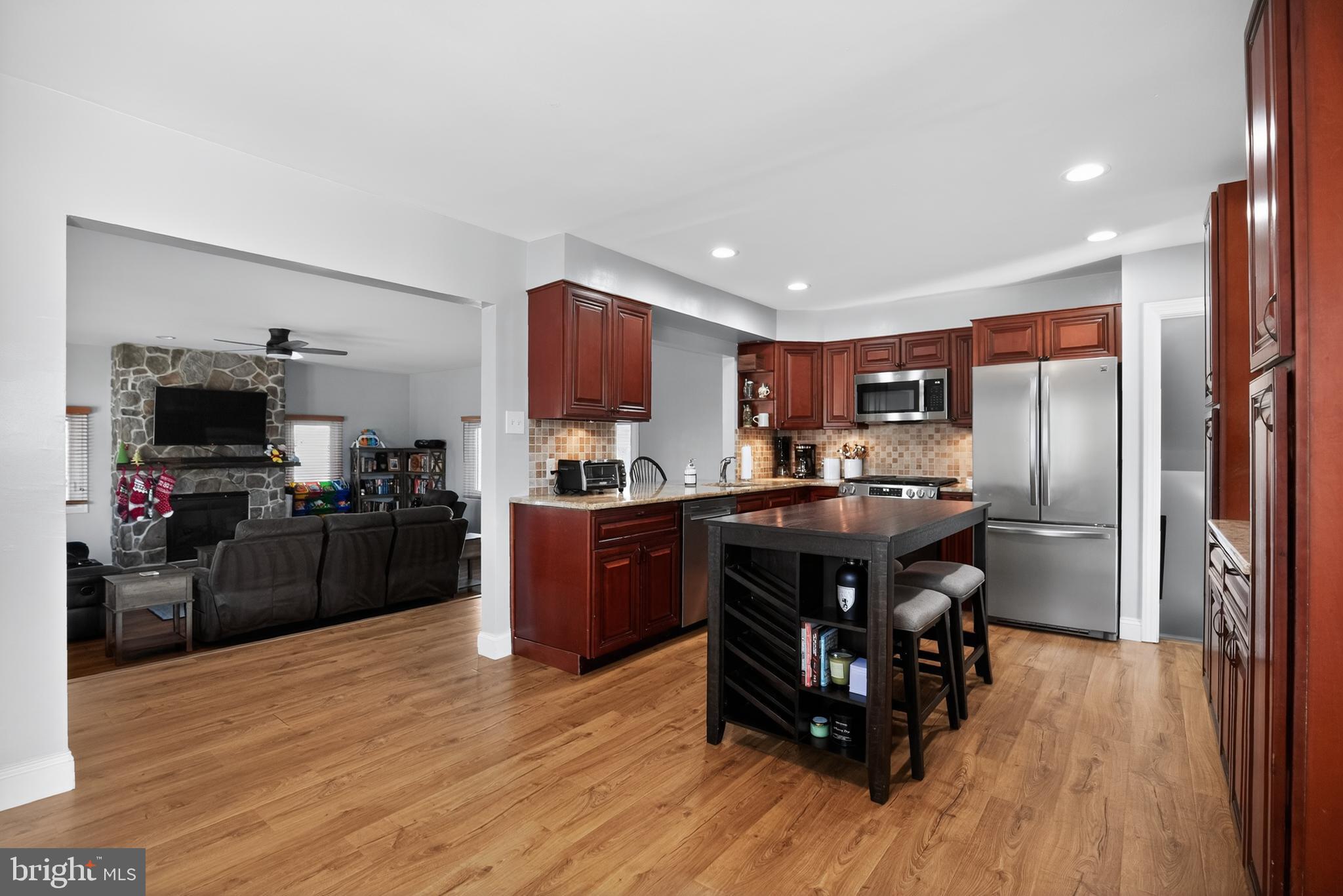 236 Hickory Road Warminster, PA 18974 - Photo 11 of 36 a kitchen with stainless steel appliances granite countertop a refrigerator a sink dishwasher a stove and a dining table with wooden floor
