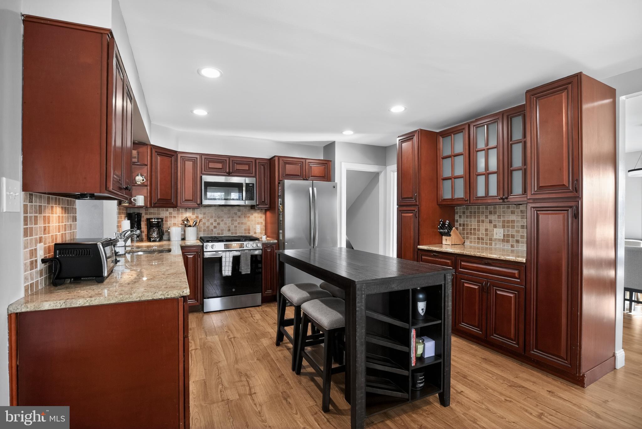 236 Hickory Road Warminster, PA 18974 - Photo 12 of 36 a kitchen with stainless steel appliances granite countertop wooden cabinets a refrigerator a stove a sink and a microwave