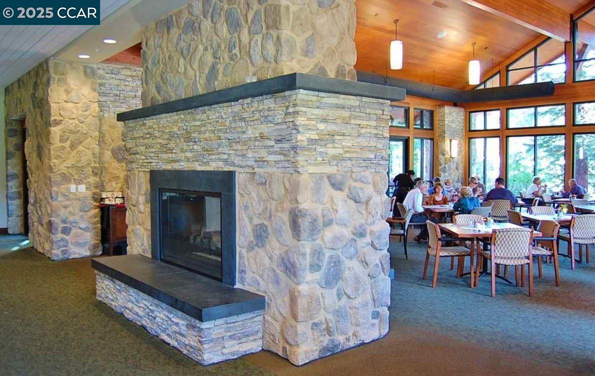 1832 Golden Rain Road, Unit 6 Walnut Creek, CA 94595 - Photo 16 of 36 a living room with furniture a fireplace and a floor to ceiling window