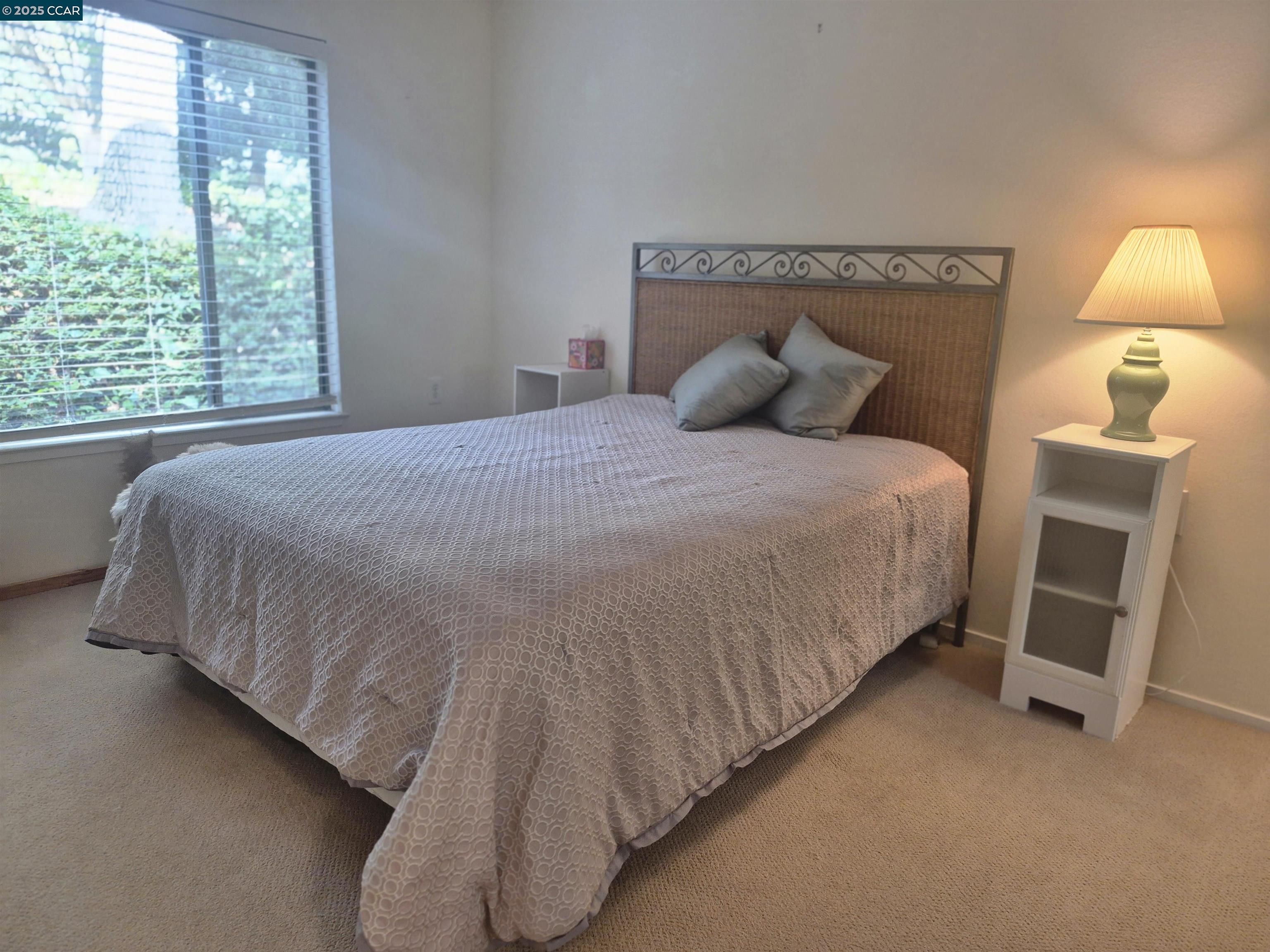 1832 Golden Rain Road, Unit 6 Walnut Creek, CA 94595 - Photo 9 of 36 a large bed sitting in a bedroom next to a lamp