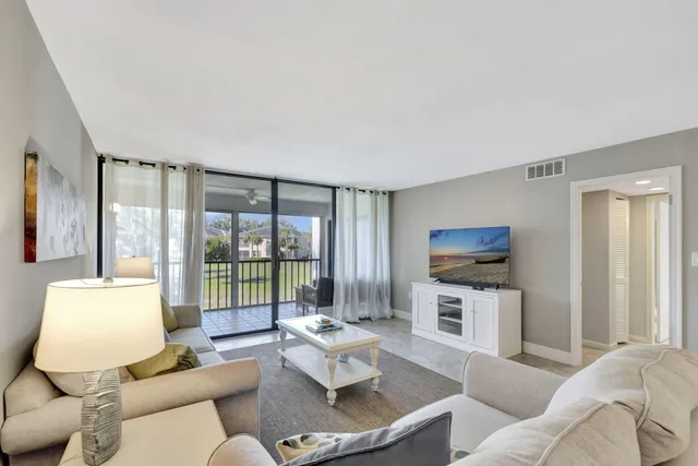 a living room with furniture a flat screen tv and a large window