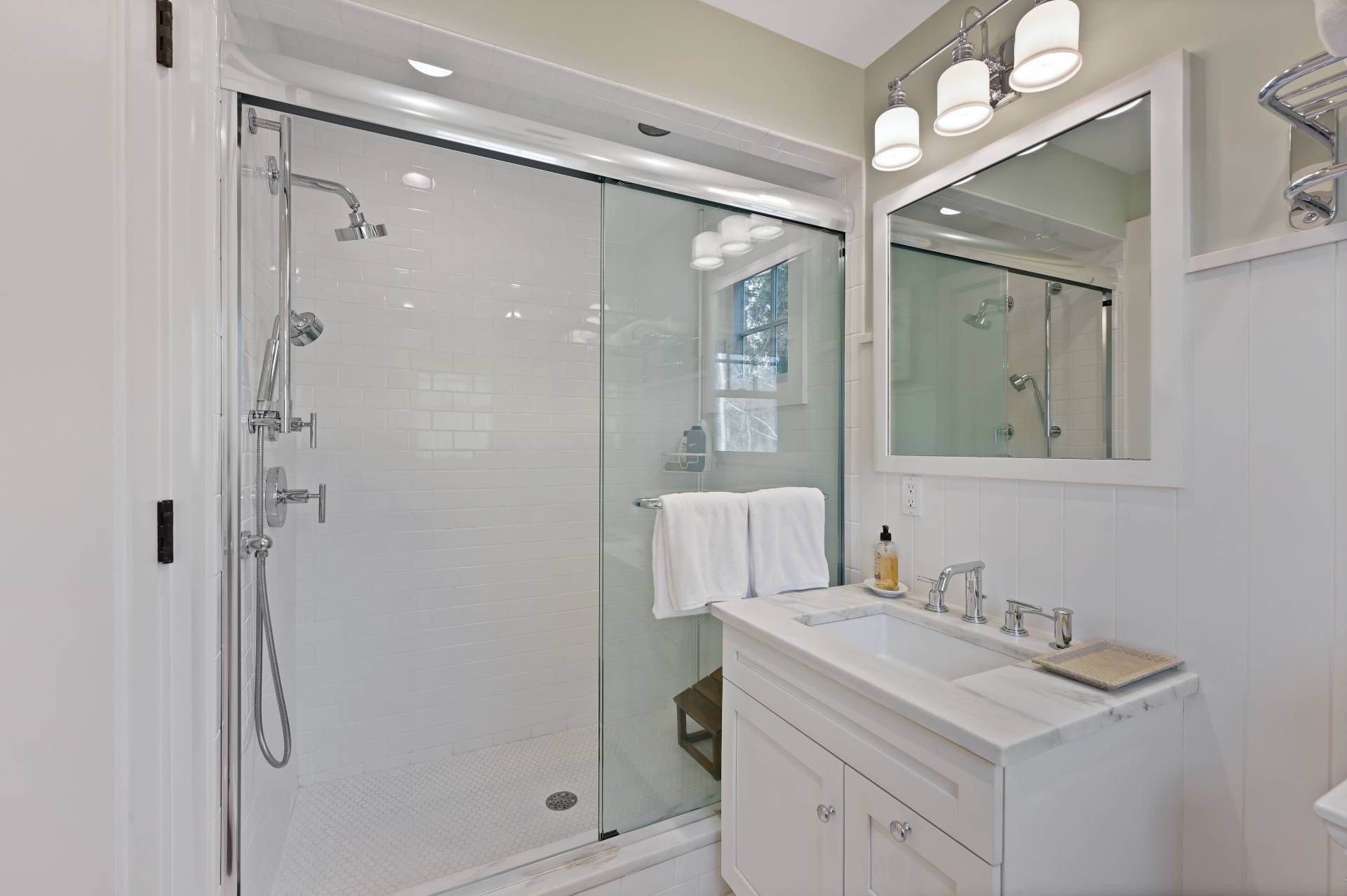 5 Ridge Drive Sag Harbor, NY 11963 - Photo 25 of 27 a bathroom with a shower sink vanity and mirror