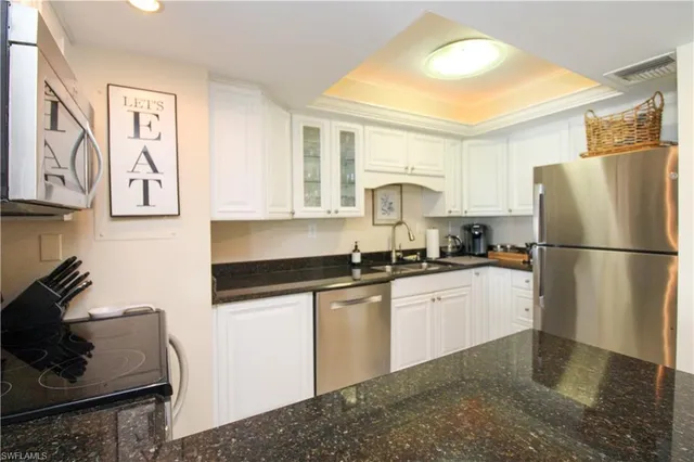 a kitchen with stainless steel appliances granite countertop a refrigerator a stove and a sink