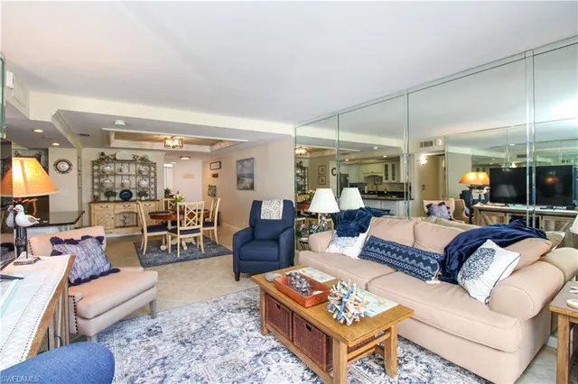 a living room with furniture a table and a large window