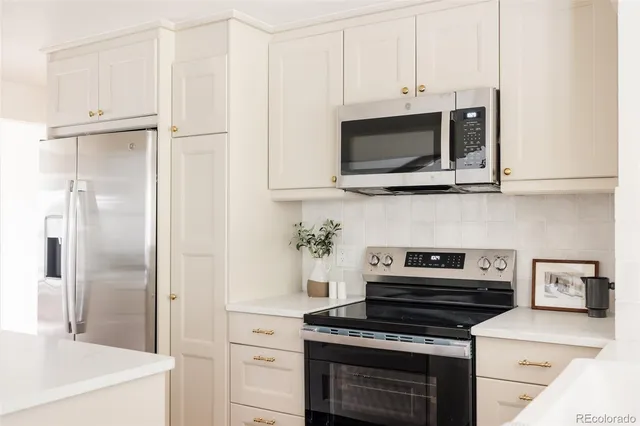 a kitchen with stainless steel appliances a stove a microwave and cabinets