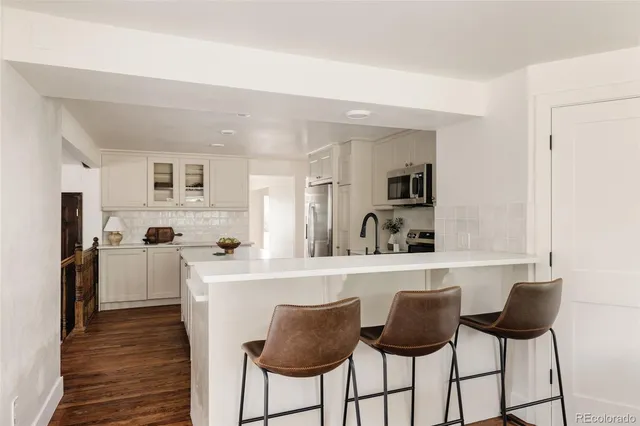 a kitchen with stainless steel appliances granite countertop a refrigerator and a stove top oven