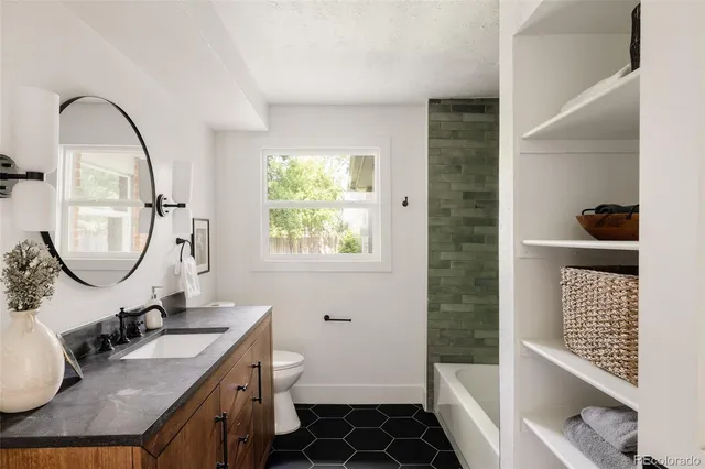 a bathroom with a sink a toilet and a mirror