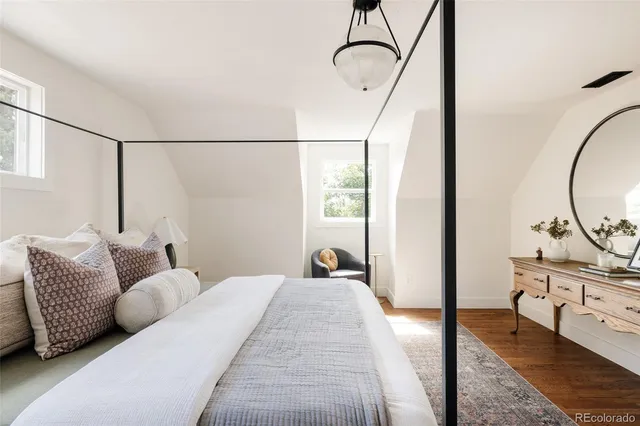 a bedroom with a bed a mirror and desk