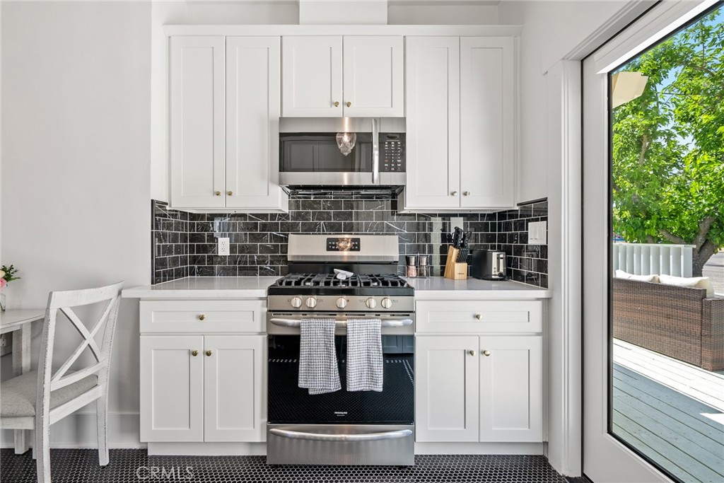 1444 Oak Street Paso Robles, CA 93446 - Photo 13 of 40 a kitchen with white cabinets and appliances