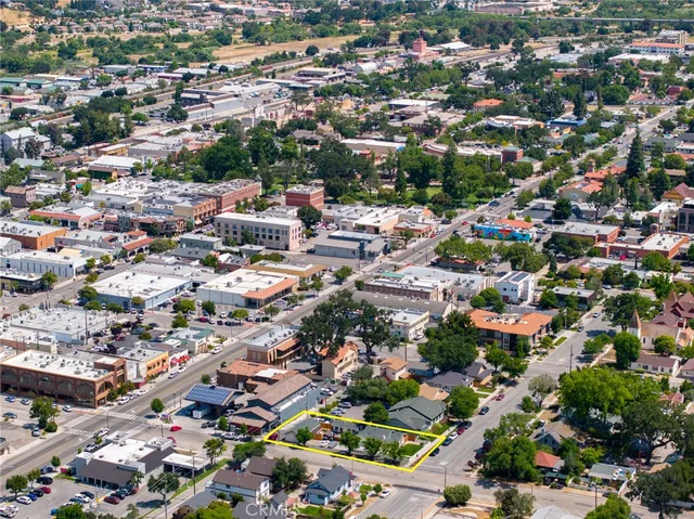an aerial view of residential houses with outdoor space and trees