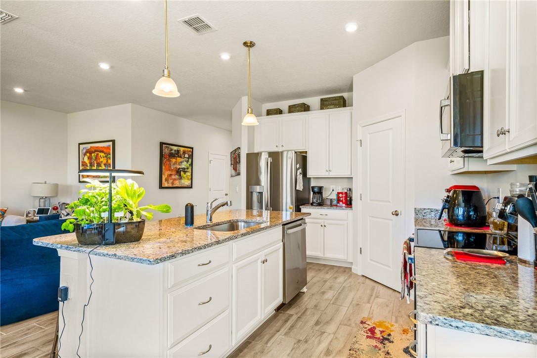 4202 Keeson Circle Vero Beach, FL 32967 - Photo 11 of 36 a kitchen that has a lot of cabinets a sink and wooden floor
