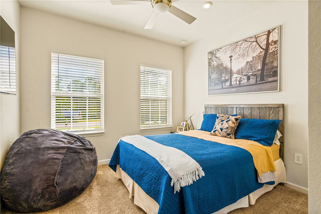 4202 Keeson Circle Vero Beach, FL 32967 - Photo 20 of 36 a bed sitting in a bedroom next to a window and a chandelier