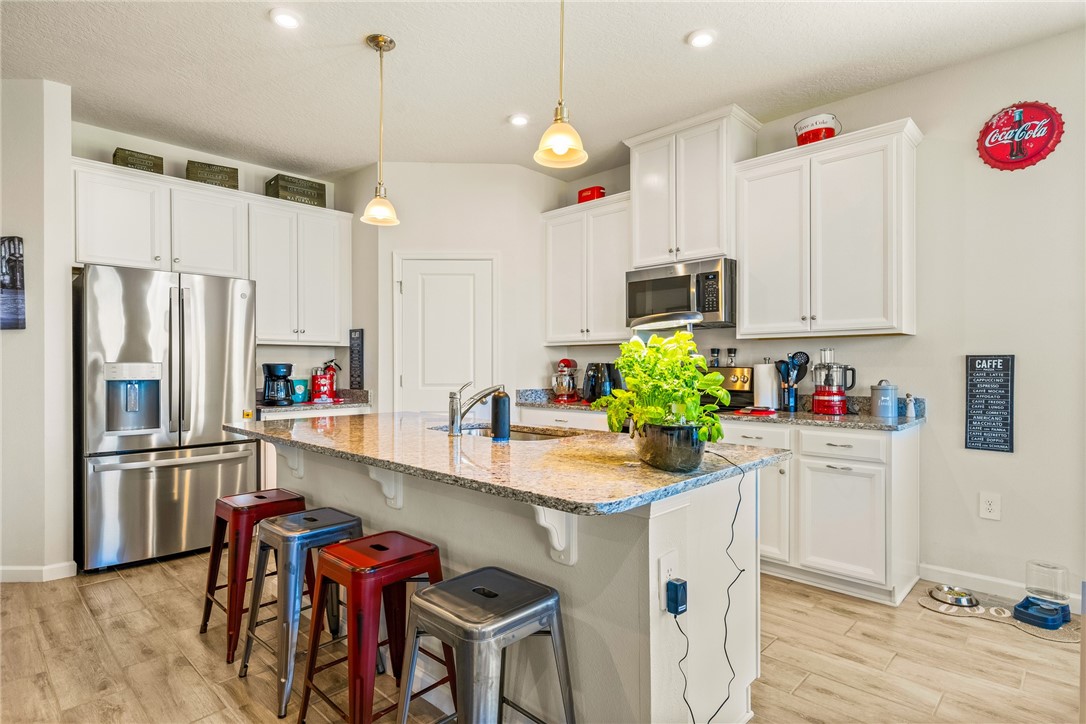 4202 Keeson Circle Vero Beach, FL 32967 - Photo 6 of 36 a kitchen with kitchen island a stove a sink and a refrigerator