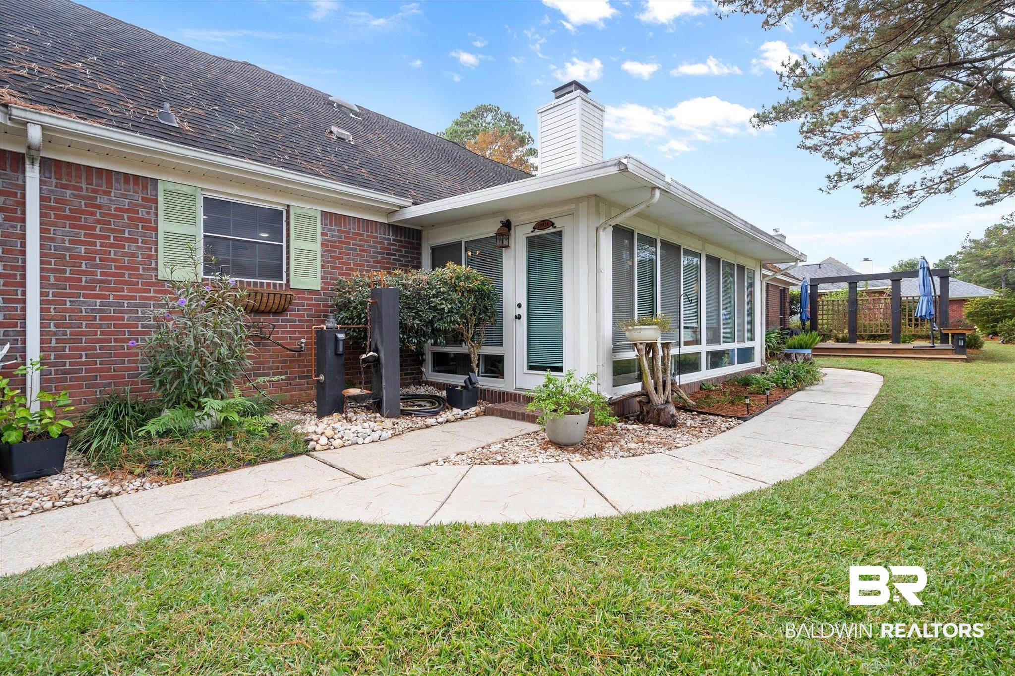 19924 Hunters Loop Fairhope, AL 36532 - Photo 29 of 40 View of front facade with a sunroom, a deck, and a front yard
