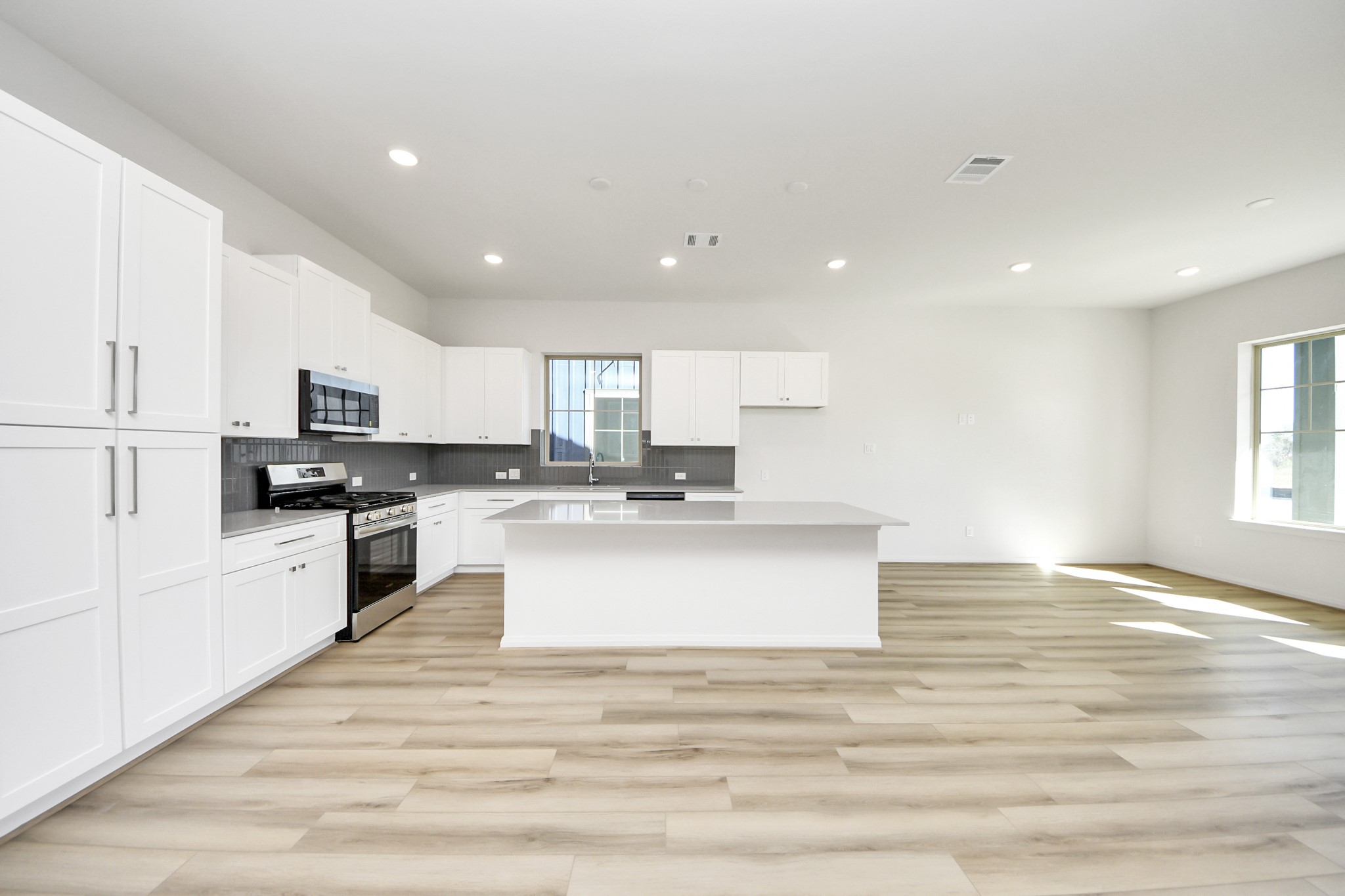 363 Legacy Point, Unit A Sealy, TX 77474 - Photo 13 of 26 a large kitchen with kitchen island a sink a center island stainless steel appliances and a window