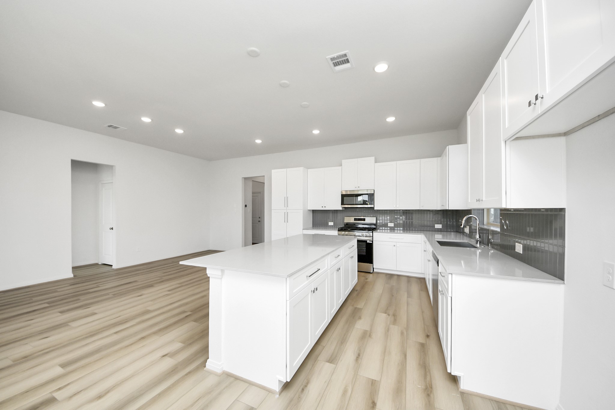 363 Legacy Point, Unit A Sealy, TX 77474 - Photo 17 of 26 a large white kitchen with wooden floor and a sink