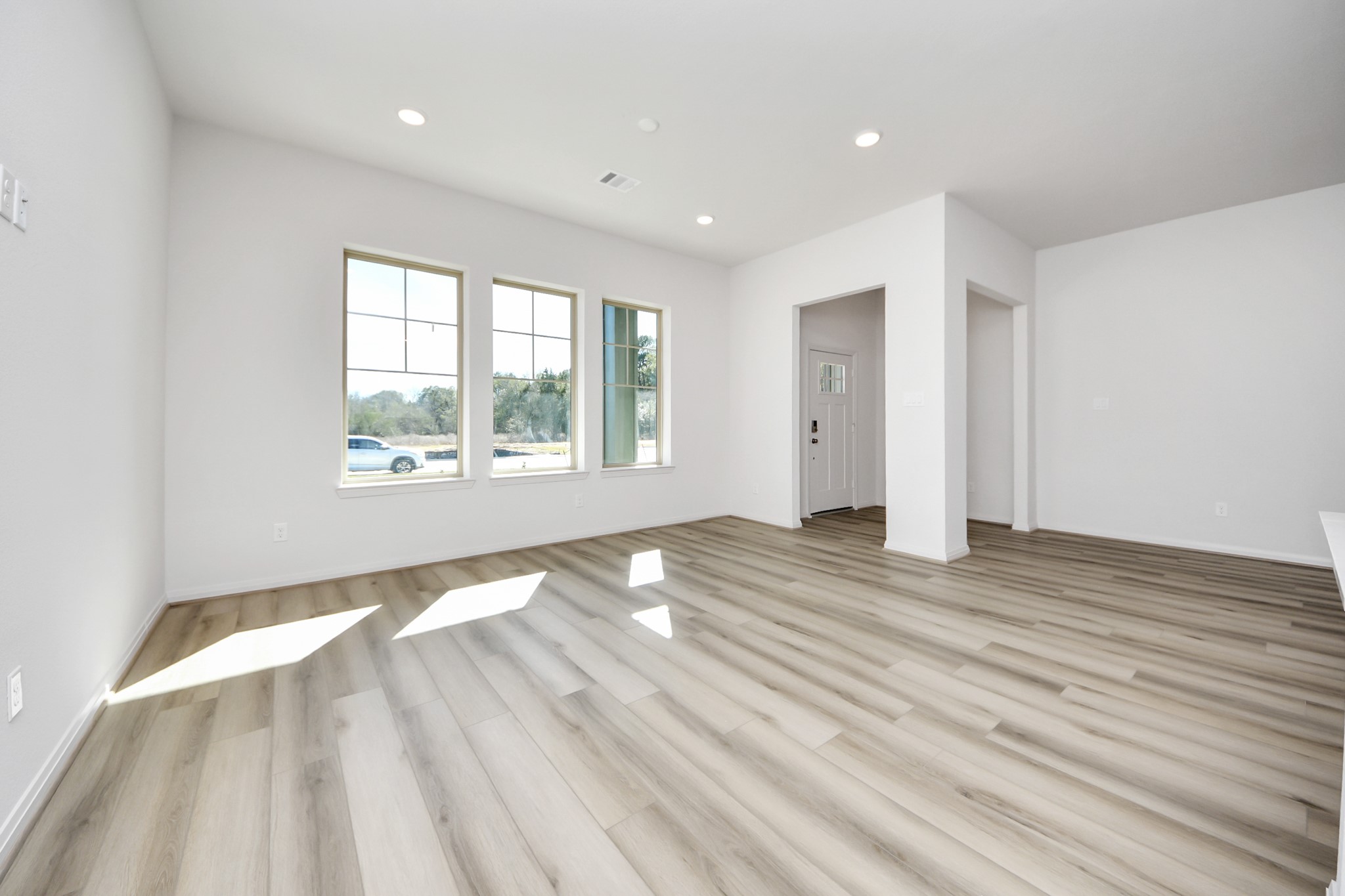 363 Legacy Point, Unit A Sealy, TX 77474 - Photo 5 of 26 an empty room with wooden floor and windows