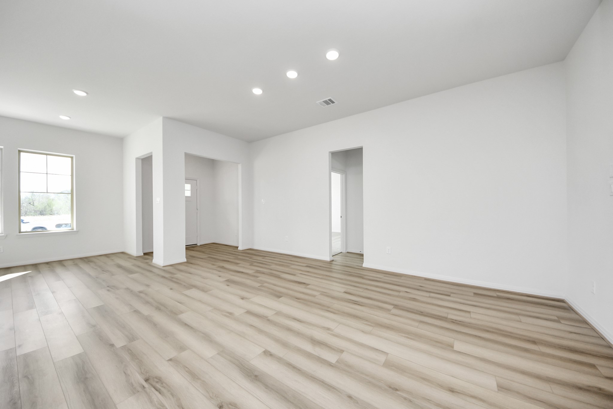 363 Legacy Point, Unit A Sealy, TX 77474 - Photo 7 of 26 a view of an empty room with wooden floor and a window