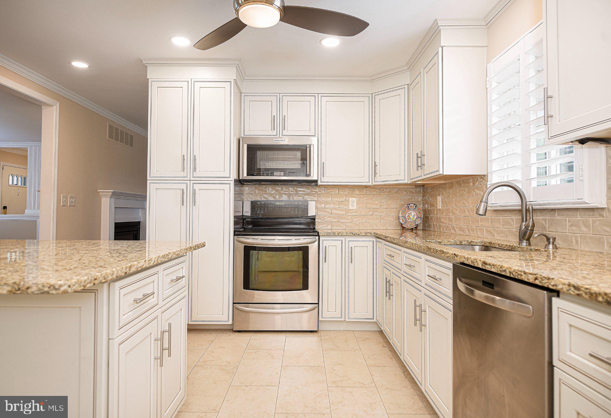 14300 Carroll Ridge Court Baldwin, MD 21013 - Photo 5 of 73 a kitchen with granite countertop a sink stainless steel appliances and white cabinets