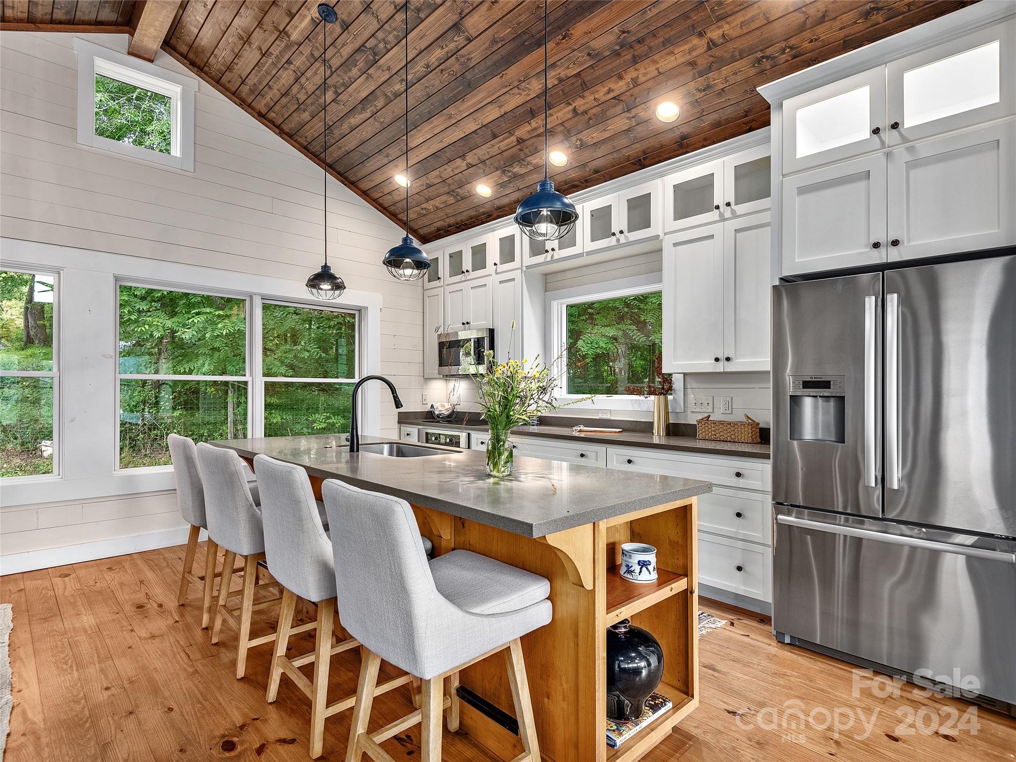 2560 King Road Pisgah Forest, NC 28768 - Photo 24 of 44 a kitchen with stainless steel appliances granite countertop a stove a refrigerator a kitchen island a table and chairs