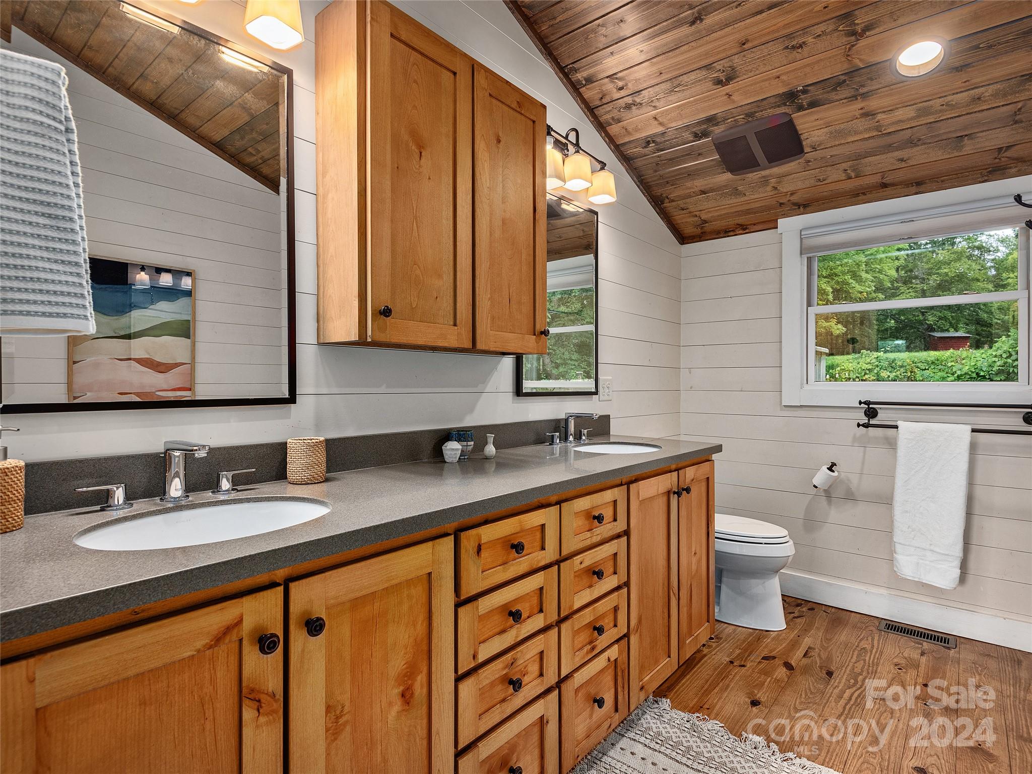 2560 King Road Pisgah Forest, NC 28768 - Photo 28 of 44 a bathroom with a granite countertop sink a toilet a mirror and a window