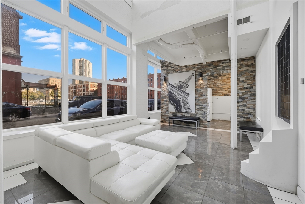 a living room with furniture a fireplace and a floor to ceiling window