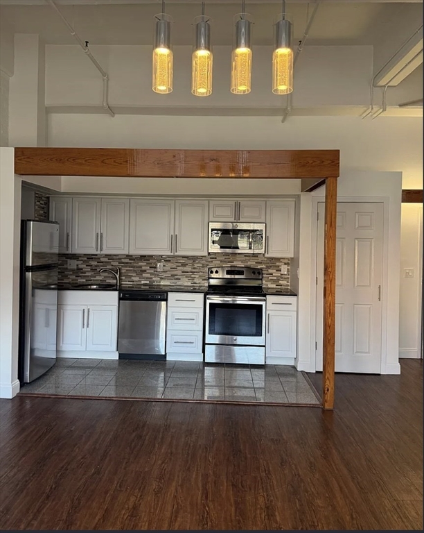11-31 Park Street, Unit 302 Springfield, MA 01103 - Photo 3 of 3 a kitchen with granite countertop a stove and cabinets