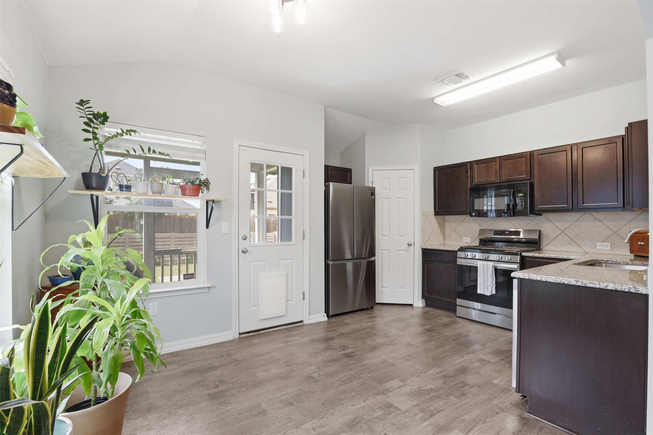 13804 Sierra Wind Lane Elgin, TX 78621 - Photo 8 of 29 a kitchen with stainless steel appliances a refrigerator sink and microwave