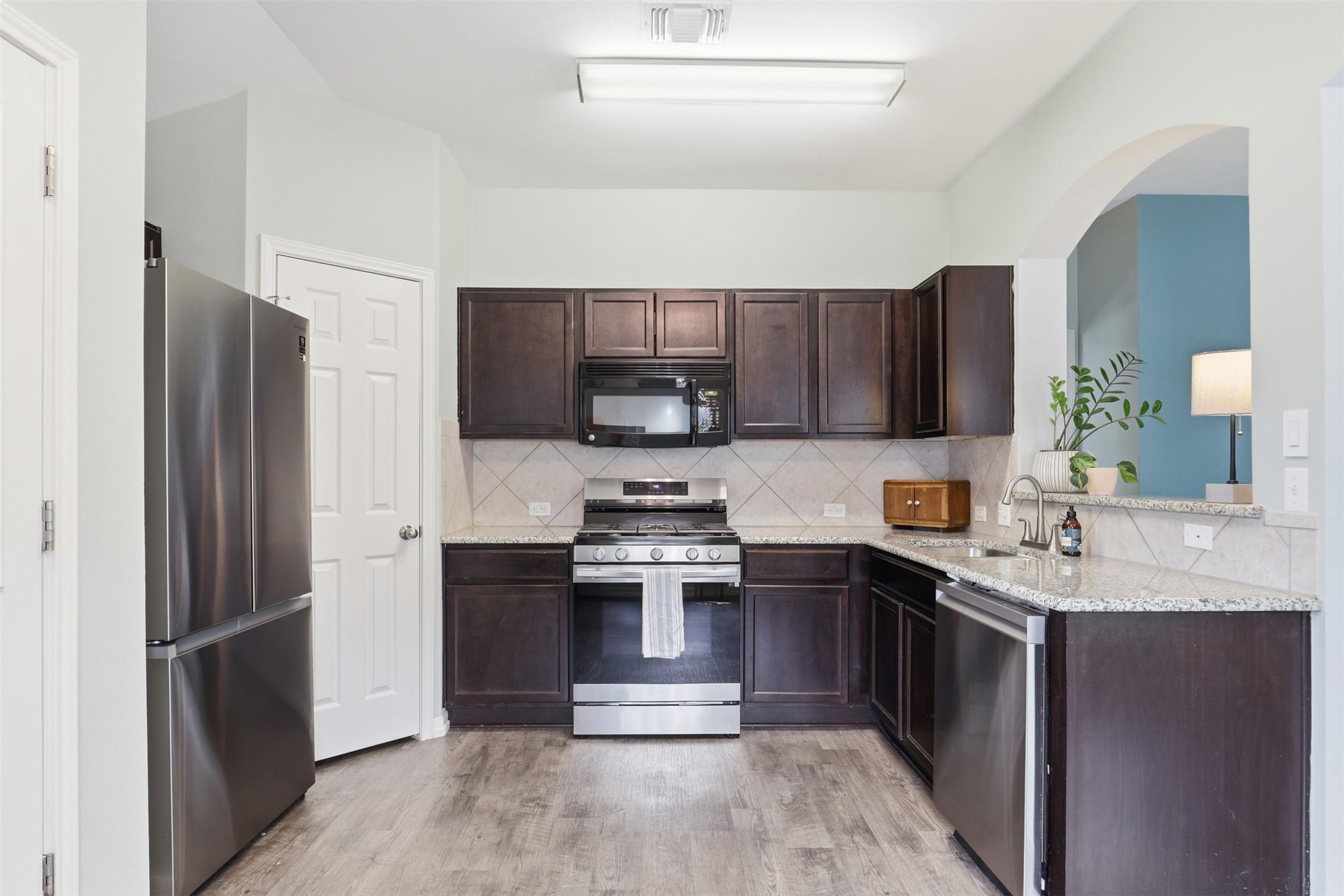 13804 Sierra Wind Lane Elgin, TX 78621 - Photo 10 of 29 a kitchen with stainless steel appliances granite countertop a refrigerator stove a sink and a microwave