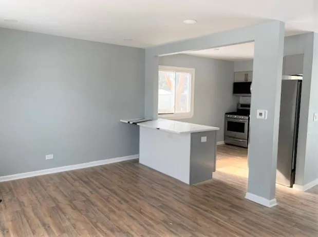 a view of a kitchen with wooden floor and electronic appliances