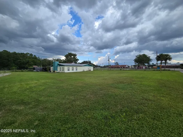 a view of a house with a big yard and a large tree