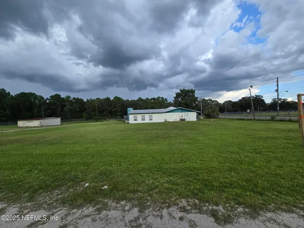 a view of a big yard with a house in the background