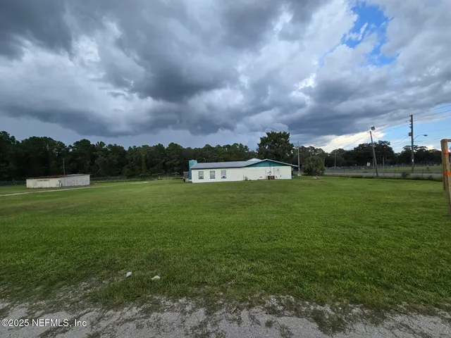 a view of a big yard with a house in the background