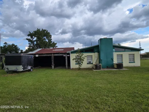 a view of a house with backyard sitting area and garden