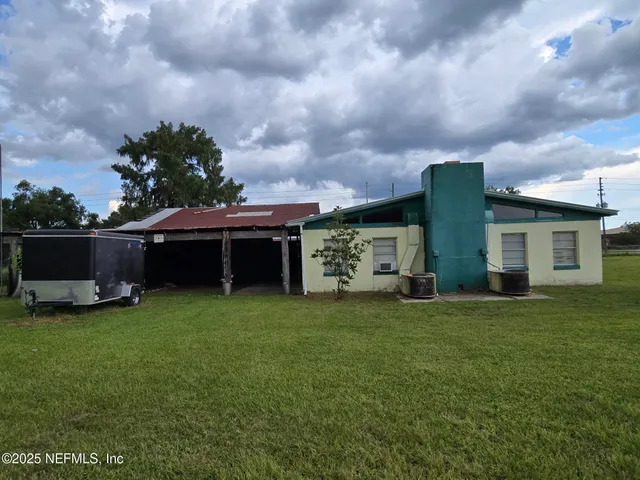 a view of a house with backyard sitting area and garden