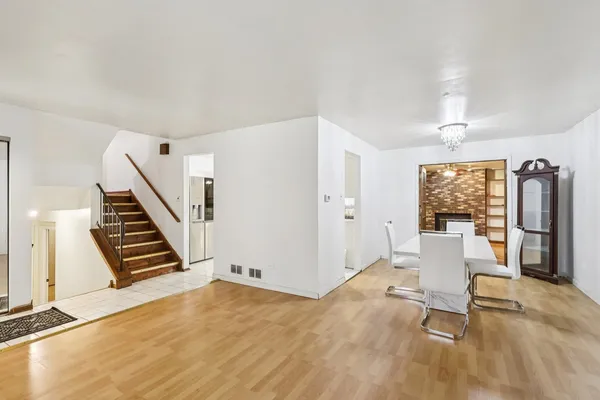 a view of a livingroom with wooden floor and furniture