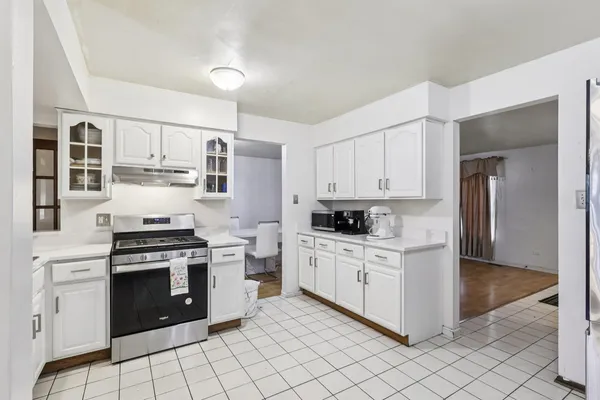 a kitchen with white cabinets and appliances