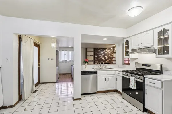 a kitchen with white cabinets and white appliances