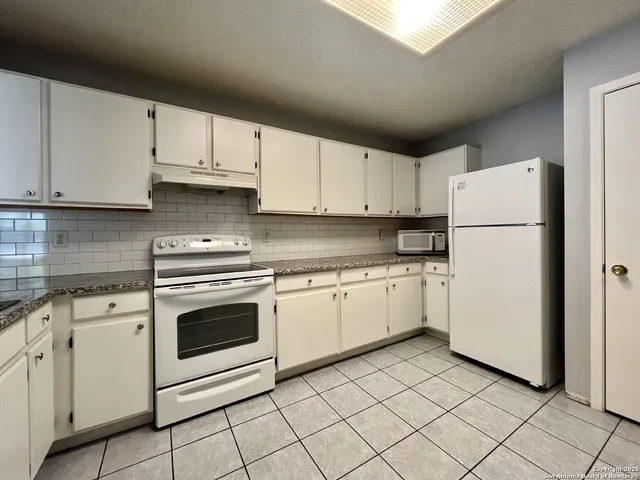 a kitchen with cabinets stainless steel appliances and sink