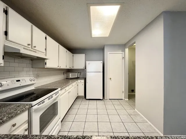 a kitchen with a sink a stove cabinets and refrigerator