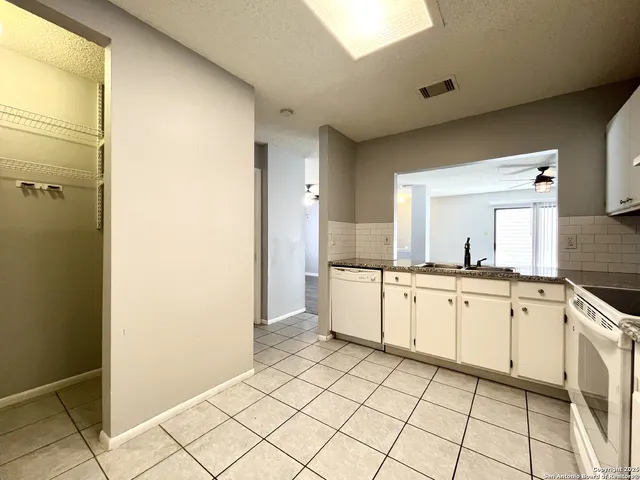 a large bathroom with a granite countertop sink a mirror and a bathtub