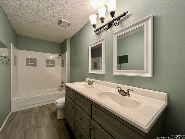 a bathroom with a sink a toilet and mirror