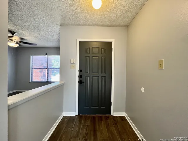 a view of a hallway with wooden floor and a window