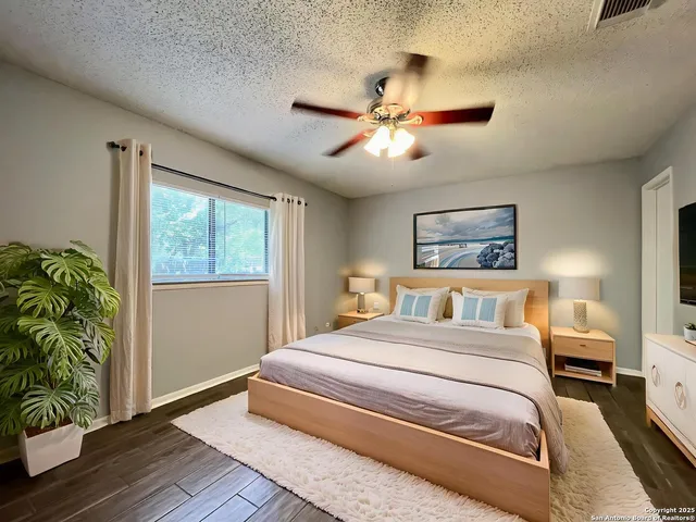 a bedroom with a large bed and a chandelier